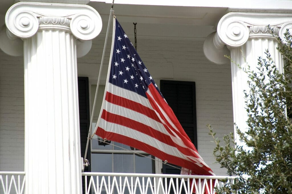 Exterior of the Texas Governor's Mansion with an American flag flying in the breeze